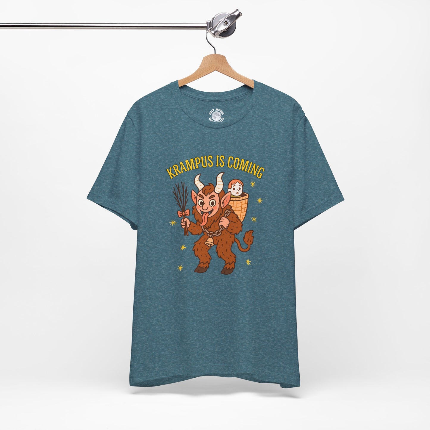 Blue t-shirt with Krampus graphic and "Krampus is Coming" text on a hanger against a white background