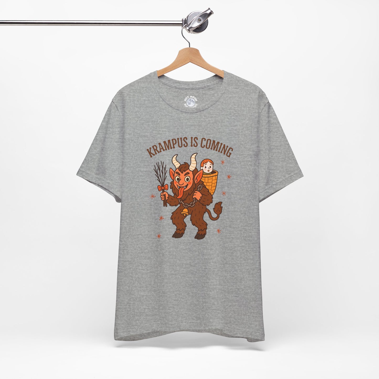 Gray t-shirt with Krampus graphic and text 'Krampus is Coming' on a hanger against a white background