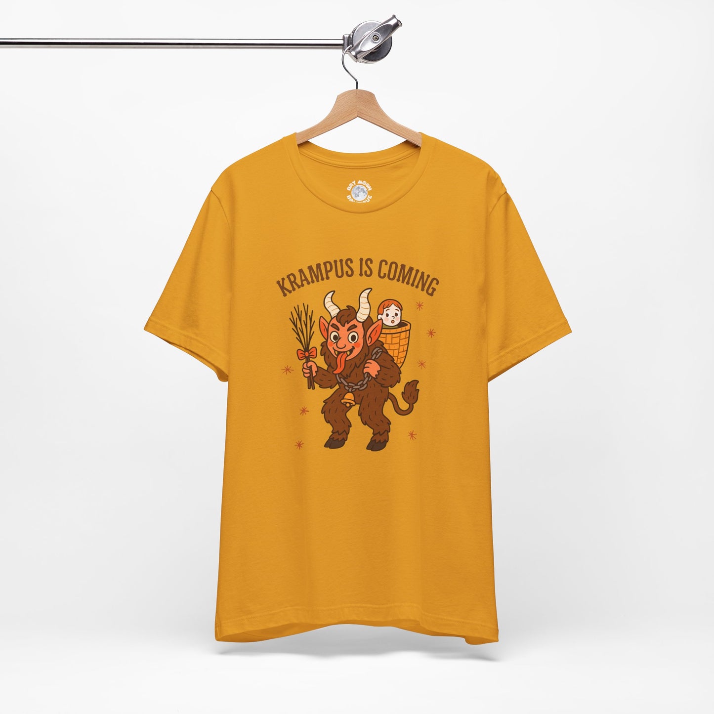 Yellow t-shirt with Krampus graphic and text 'Krampus is Coming' on a hanger against a white background