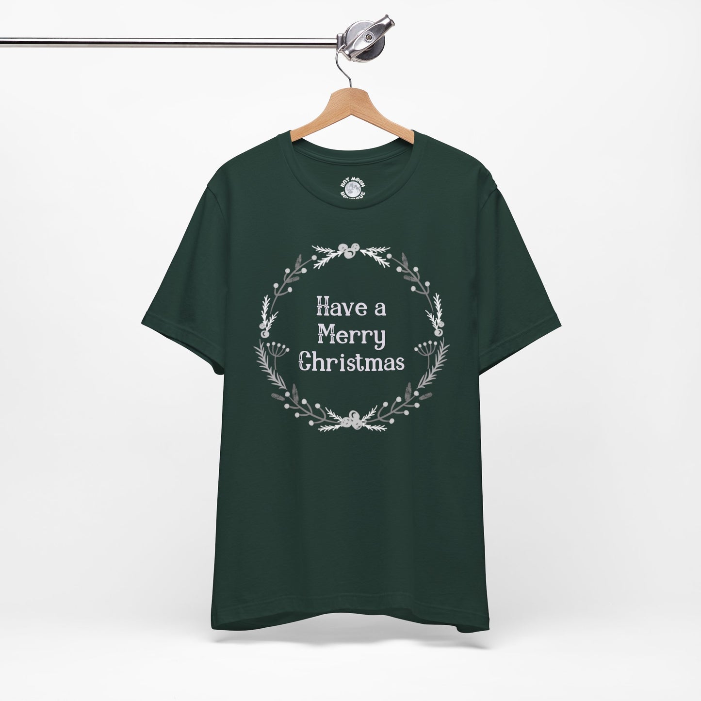 Green t-shirt with 'Have a Merry Christmas' text on a hanger against a white background