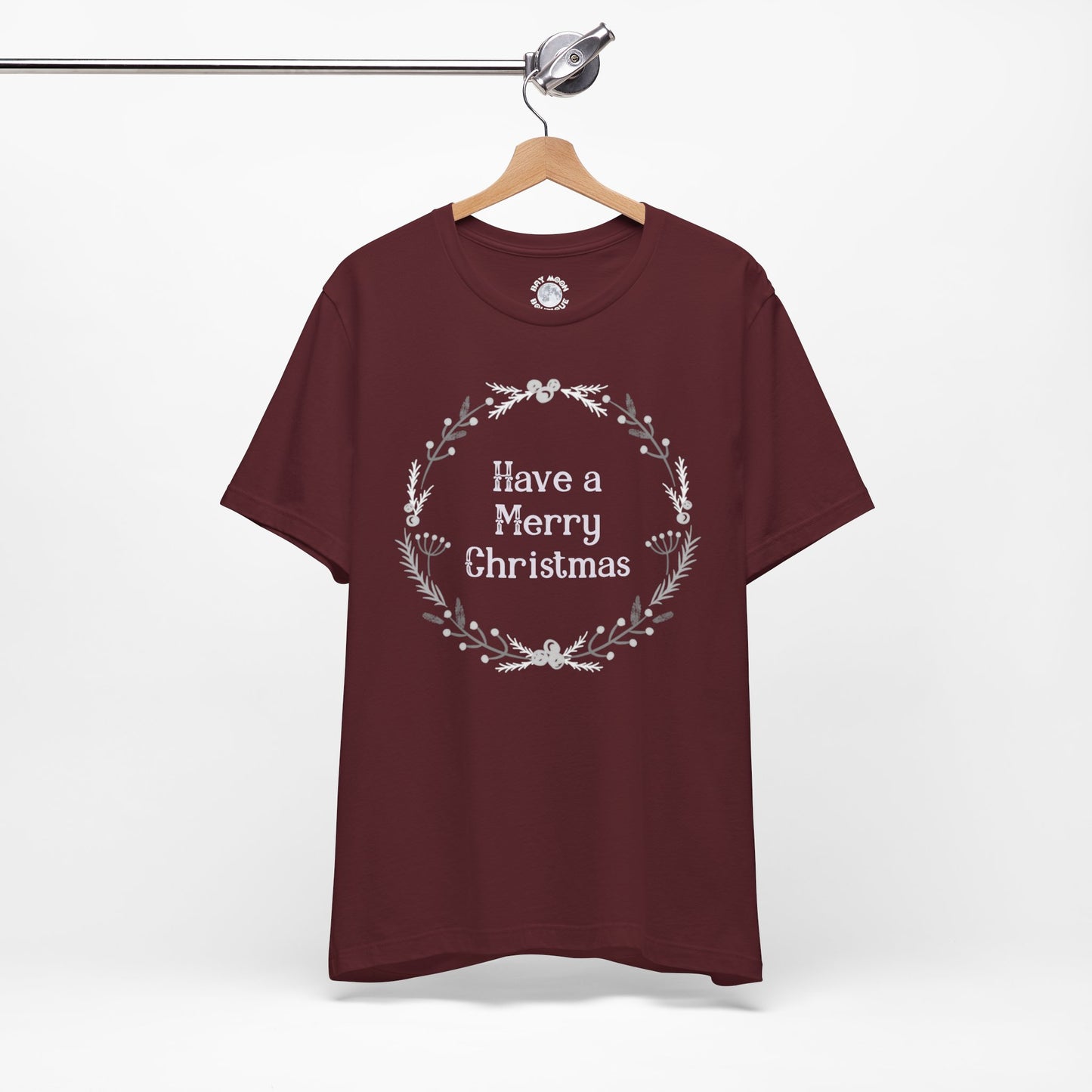 Maroon t-shirt with 'Have a Merry Christmas' text on a hanger against a white background